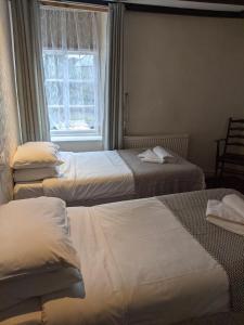 利德尼George Inn st briavels的酒店客房设有三张床和窗户。