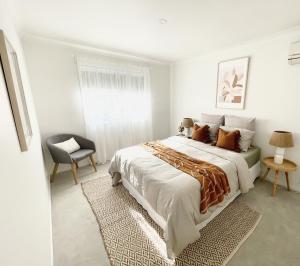 黄金海岸Gold Coast uninterrupted uphill view & big pool的白色卧室配有一张大床和椅子