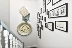 伯明翰Townhouse @ Aboyne Close Birmingham的墙上挂着时钟和照片的楼梯