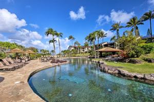 普林斯维尔Hanalei Bay Resort 2301的一个带椅子和棕榈树的度假村游泳池