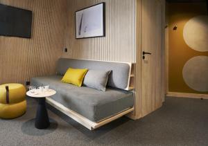 阿沃里亚兹Hôtel MiL8的一张沙发,配有两个枕头和一张桌子