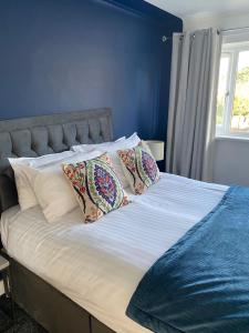 谢菲尔德Stylish 3 bed house, private parking, garden and conservatory close to town centre的一张带两个枕头和蓝色墙壁的床