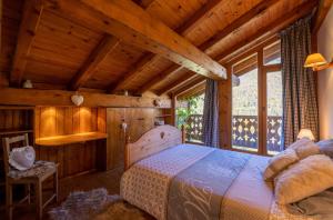 谷雪维尔Magnifique chalet authentique au cœur des 3 vallées的卧室配有一张床铺,位于带木墙的房间内
