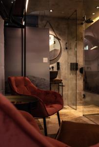 拉巴特The Heritage Boutique Accommodation的一间带红色椅子和淋浴的浴室