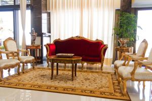 纳塔尔Majestic Ponta Negra Beach,WorldHotels Elite的客厅配有红色的沙发和桌子