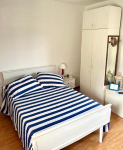 坦迪尔Habitación Caléndulas- Hospedaje Lo De Juan Y Mabel的白色卧室配有蓝色和白色条纹床