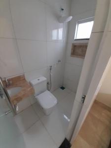 阿鲁阿南CASA ARUANÃ 5 SUITES的白色的浴室设有卫生间和窗户。