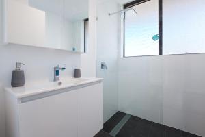 尼尔森湾Bellevue, 7 4 Donald Street - renovated unit with air con and Wi-Fi with views & central to CBD的白色的浴室设有水槽和窗户。