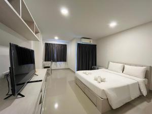 曼谷Donmueang Place Hotel - SHA Plus的一间卧室配有一张床和一台平面电视