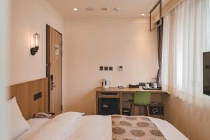 花莲市东城商旅的配有一张床和一张书桌的酒店客房