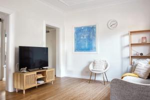 悉尼Manly Cosy Retreat - Short walk to beach的客厅配有平面电视和椅子。