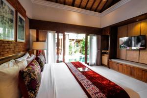 塞米亚克Sampatti Villas的一间带大床和电视的卧室