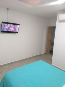 比亚维森西奥APARTA ESTUDIO CONDO的一间设有床铺和墙上电视的客房