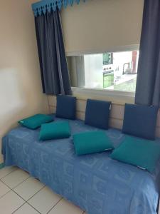 莱特鲁瓦西莱Res MARINA-CARAYOU 1的窗户间内的一张带蓝色枕头的床