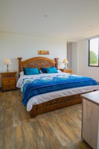 派帕Casa El Roble paipa的一间卧室配有一张带蓝色枕头的大床