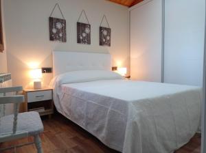 奥尔梅多Magia en el Arco的卧室配有一张白色大床和一把椅子