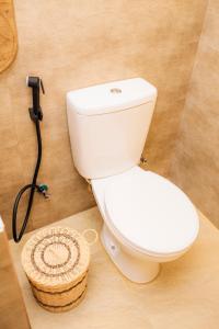 坦加拉Igabara Hobbit House的浴室内的一个白色厕所,并备有一个篮子