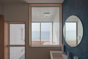 ItoshimaALFACIO RESORT STAY ITOSHIMA的浴室设有镜子、水槽和窗户