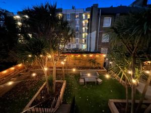 伦敦斯文顿酒店的棕榈树和灯光的庭院