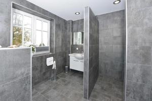 拉尔斯维克STöRTEBEKER APPARTEMENTS - "BLAUES HAUS"的灰色的浴室设有水槽和镜子