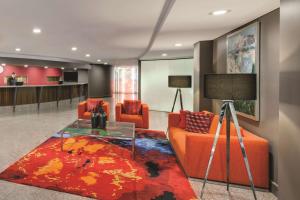 堪培拉堪培拉詹姆斯阁阿迪纳服务式公寓式酒店的客厅配有橙色沙发和玻璃桌