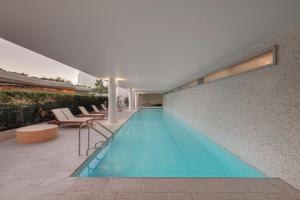 悉尼悉尼邦迪海滩阿迪娜公寓式酒店的一座建筑物中央的游泳池