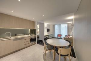 悉尼悉尼邦迪海滩阿迪娜公寓式酒店的厨房以及带桌椅的用餐室。