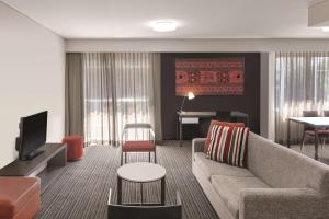 达尔文达尔文海滨阿迪娜公寓酒店的带沙发和钢琴的客厅