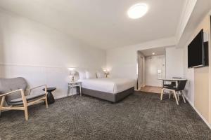达尔文达尔文旅程住宿酒店的配有一张床和一台平面电视的酒店客房