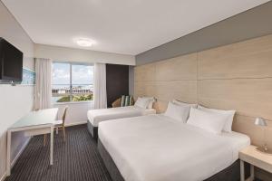 达尔文达尔文海滨盛传酒店的酒店客房设有两张床、一张书桌和一个窗户。
