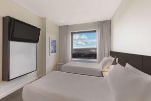 珀斯阿迪娜珀斯公寓酒店的一间卧室配有一张床和一台平面电视