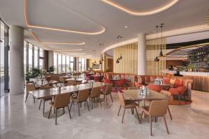 堪培拉堪培拉盛传酒店 的一间带桌椅的餐厅和一间酒吧