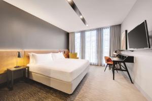 堪培拉堪培拉盛传酒店 的配有一张床和一张书桌的酒店客房