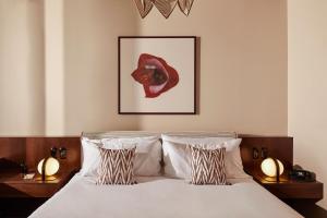 布鲁塞尔The Hoxton, Brussels的一间卧室配有一张带两盏灯和一张照片的床。