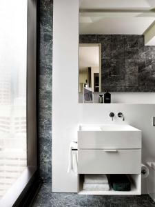 悉尼A by Adina Sydney的浴室设有白色水槽和镜子