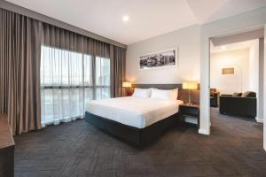 珀斯Vibe Hotel Subiaco Perth的酒店客房,配有床和沙发