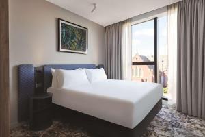 墨尔本Adina Apartment Hotel Melbourne, Pentridge的窗户客房内的一张大白色床