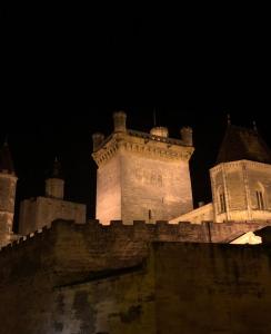 于泽斯Le 6 Bis by Les Cailloux Dorés的一座夜间有灯光的城堡
