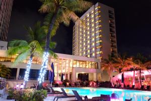 塔穆宁Guam Reef Hotel的大楼前设有游泳池的酒店