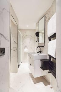巴黎牧歌度假屋的白色的浴室设有水槽和镜子
