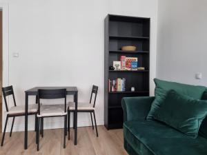 波兹南Apartament w kamienicy的客厅配有绿色沙发、桌子和椅子