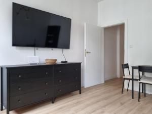 波兹南Apartament w kamienicy的客厅配有黑色梳妆台和平面电视