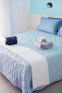 里米尼白金酒店的一张带毛巾和袋子的床