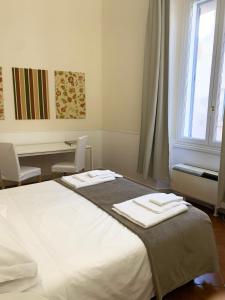 罗马维科罗多利亚公寓的一间卧室配有一张床,上面有两条毛巾