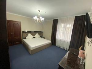 阿特劳Comfortplace的卧室配有白色的床和吊灯。