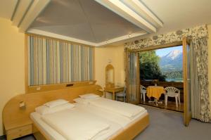 法克湖畔杜罗博拉赫施翁鲁酒店的一间卧室设有一张床和一个大窗户