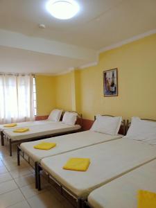潘索尔La Vista Pansol Resort Complex by RedDoorz的黄色墙壁的房间里设有三张床