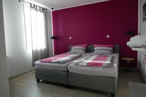 多特蒙德Pension Sölde的一间卧室设有两张床和紫色墙壁