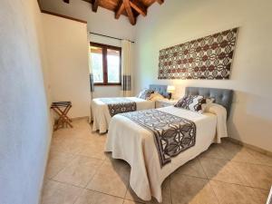 伊格莱西亚斯Saludi&Trigu - Rural Apartments的一间设有三张床的客房,配有毯子