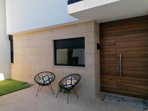 阿马兰特Casa do Golfe by VinteOito的两把椅子坐在房子前面
